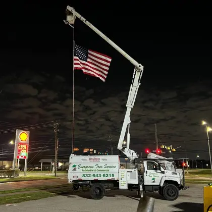 Evergreen Tree Service bucket truck with American flag at night